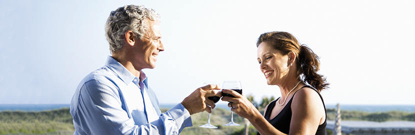 Mann und Frau stoßen mit einem Glas Wein und lächeln