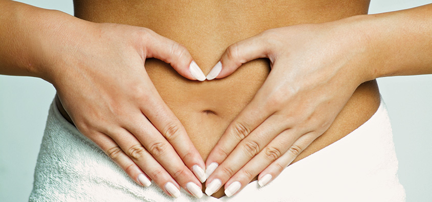 Frau bildet auf dem Bauch ein Herz mit ihren Händen. Verlinkung zum Anfang der Bestellung.