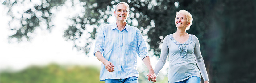 Mann und Frau Hand in Hand beim Spaziergang im Wald